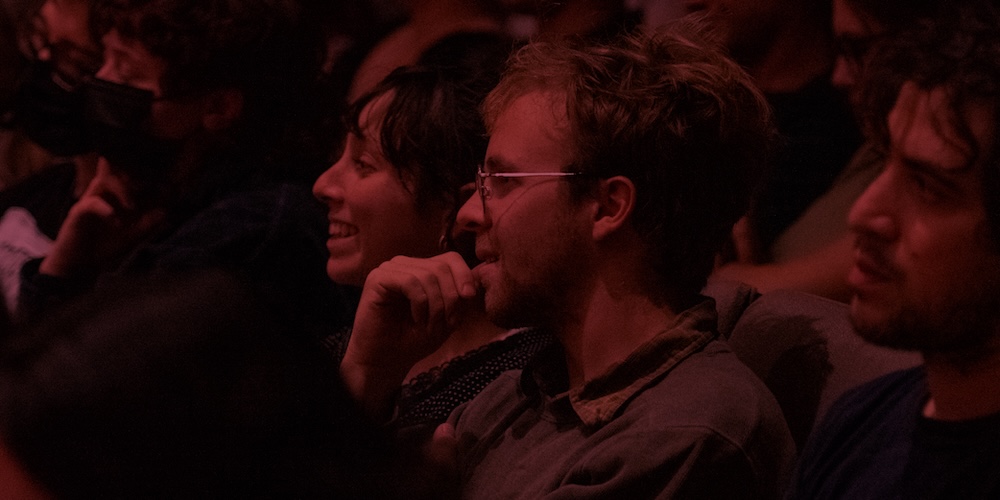 Audience watching presentation with a maroon filter on top